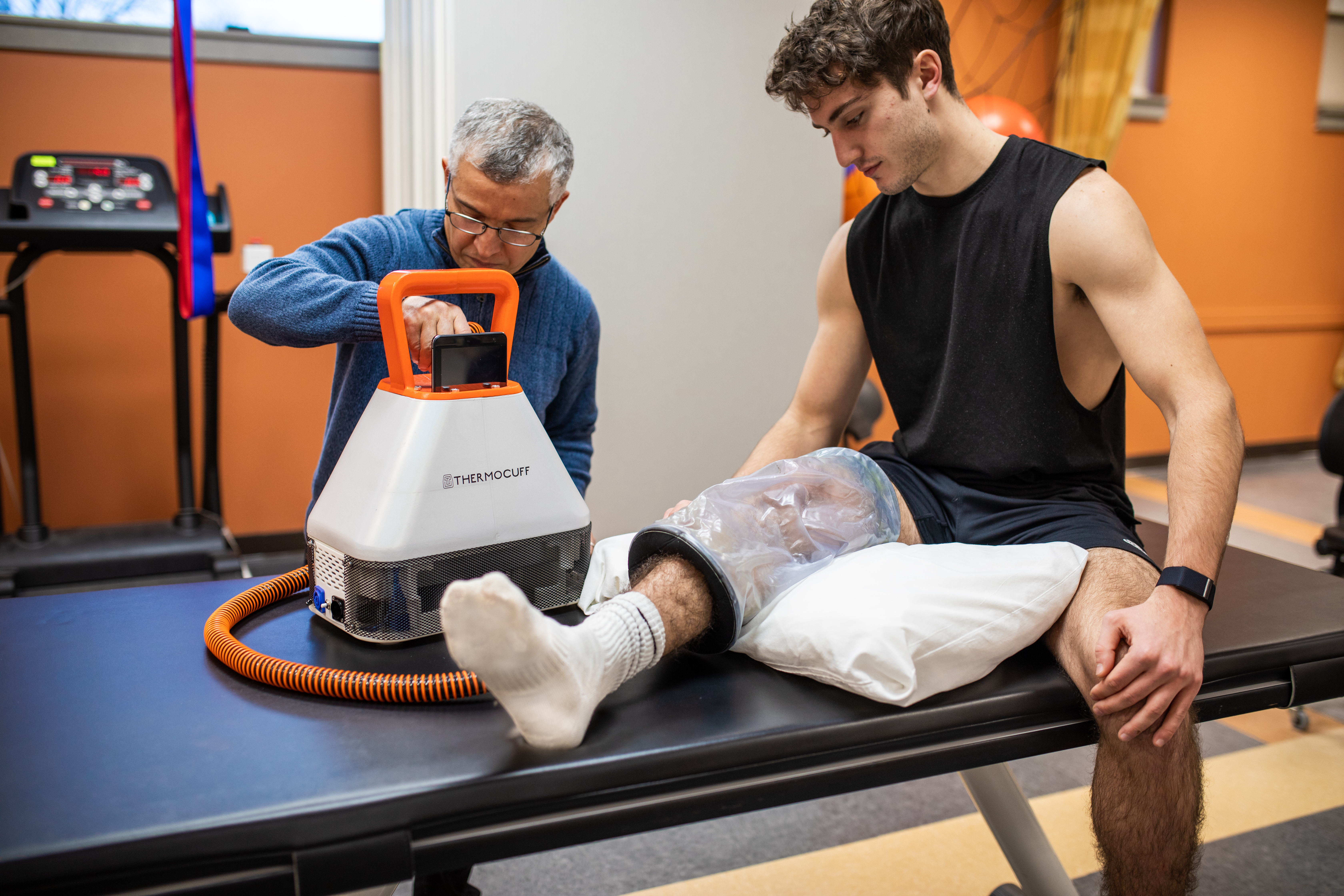 Clinician applying ThermoCuff to athlete's leg